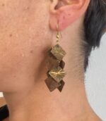 Pendientes beige artesanales con macramé y cuentas doradas, hechos en India.