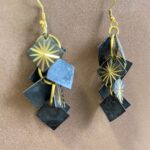 Pendientes negros de macramé sostenidos en la mano, hechos en India.