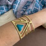 Brazalete rígido en latón dorado con piedra triangular central. Artesanal, boho y étnico. Disponible en 5 colores vibrantes.