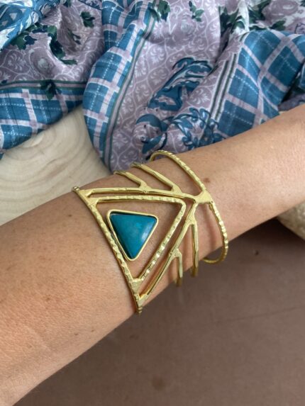 Brazalete rígido en latón dorado con piedra triangular central. Artesanal, boho y étnico. Disponible en 5 colores vibrantes.