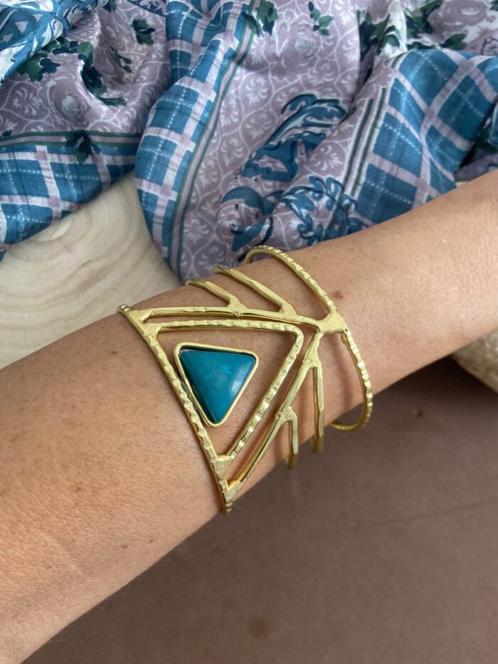 Brazalete rígido en latón dorado con piedra triangular central. Artesanal, boho y étnico. Disponible en 5 colores vibrantes.