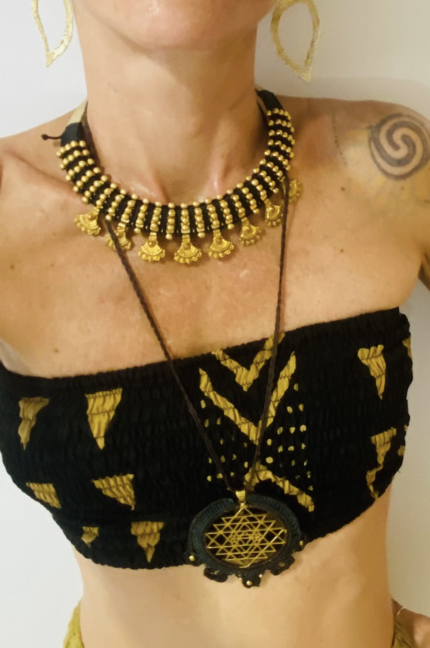 Collar rígido artesanal de latón con macramé, cuentas de colores y medallas colgantes.