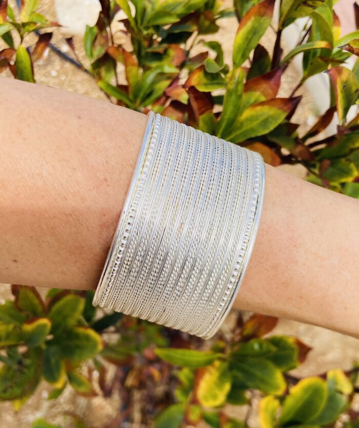 Brazalete rígido rayado en latón dorado o plateado, ajustable y artesanal.