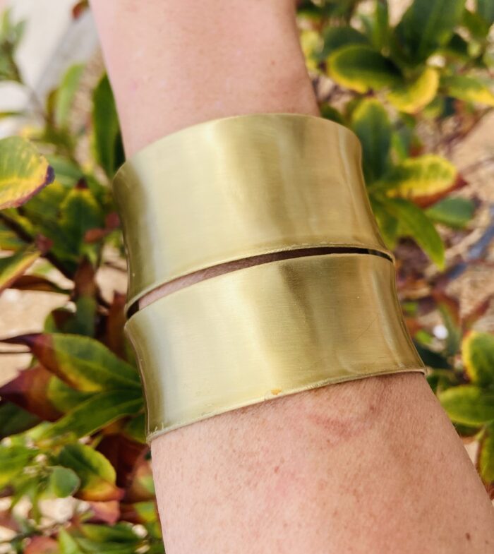 Brazalete rígido doble en latón dorado, ajustable y artesanal, estilo boho chic.