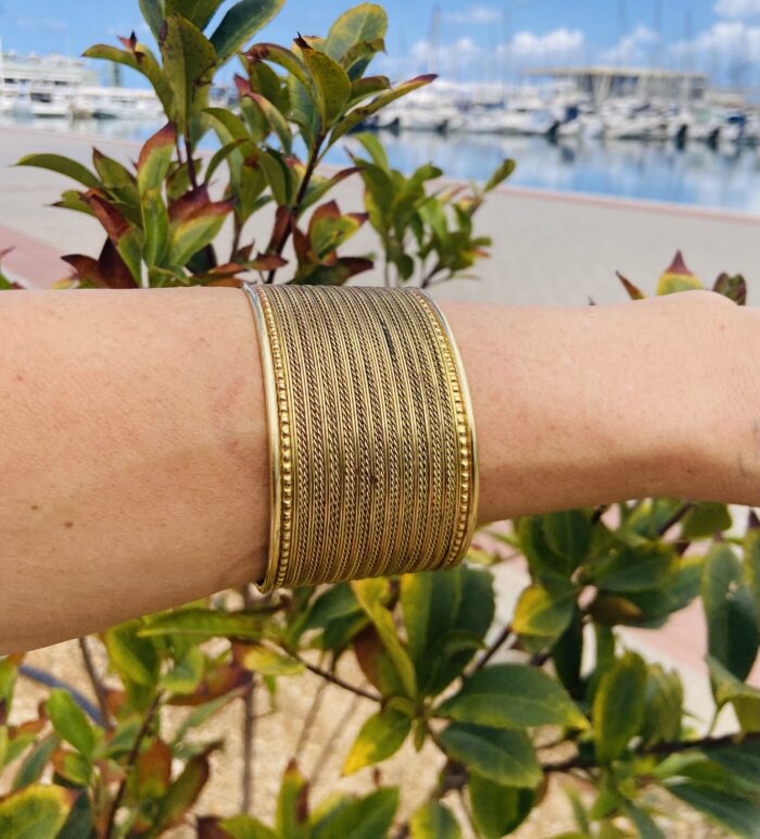 Brazalete rígido rayado en latón dorado o plateado, ajustable y artesanal.