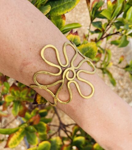 Brazalete artesanal de latón en forma de flor, ajustable y boho chic.