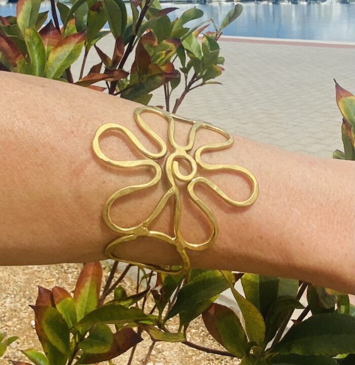 Brazalete artesanal de latón en forma de flor, ajustable y boho chic.