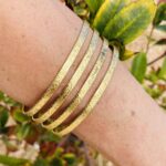 Brazalete rígido de cuatro filas en latón dorado, artesanal y boho chic.
