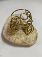 Brazalete artesanal en latón con espirales y círculos, boho chic y étnico.