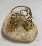 Brazalete artesanal en latón con espirales y círculos, boho chic y étnico.