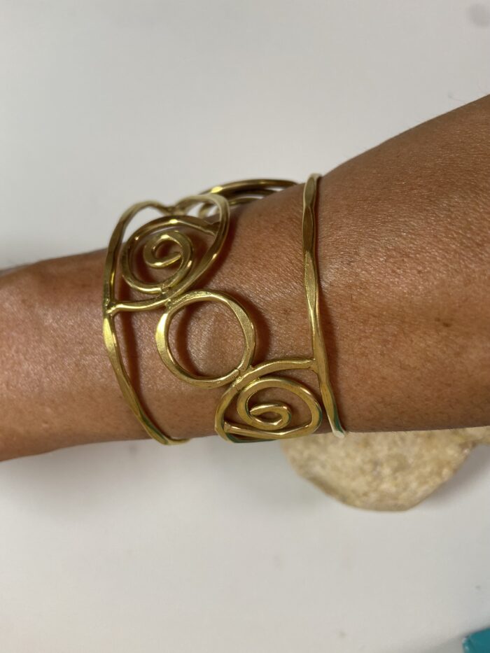Brazalete artesanal en latón con espirales y círculos, boho chic y étnico.