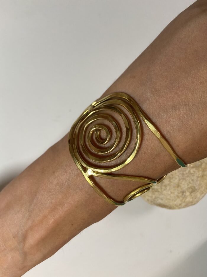 Brazalete artesanal en latón con espirales y círculos, boho chic y étnico.
