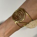 Brazalete artesanal en latón con espirales y círculos, boho chic y étnico.
