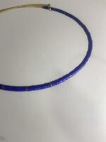 Detalle del collar artesanal de latón dorado con perlas azul, hecho a mano en India.