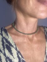 Mujer con collar rígido de latón dorado y perlas verde, hecho a mano en India, estilo boho chic.