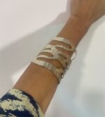 Brazalete artesanal en baño de plata ajustable, visto sobre el brazo, estilo boho chic.
