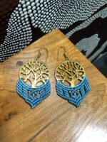 Pendientes de latón con macramé azul, artesanales, sobre mesa.
