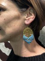 Pendientes de latón y macramé azul, usados por modelo.
