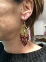 Pendientes de latón y macramé marrón, usados por modelo.