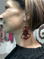 Pendientes de macramé rojos con piedra central, usados por modelo