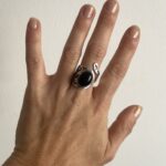 anillo con piedra negra visto desde arriba mostrando base calada circular