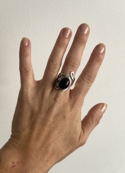 anillo con piedra negra visto desde arriba mostrando base calada circular