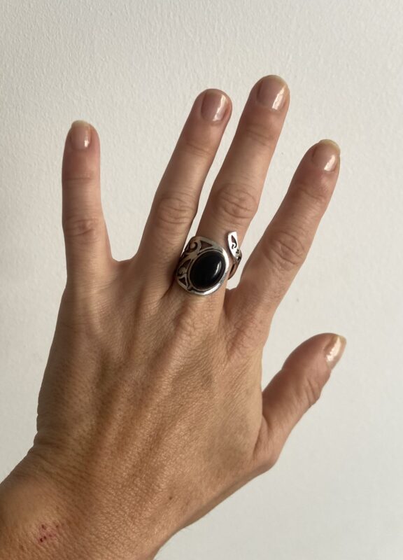 anillo con piedra negra visto desde arriba mostrando base calada circular
