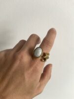 mano llevando anillo en latón con piedra blanca y estrella